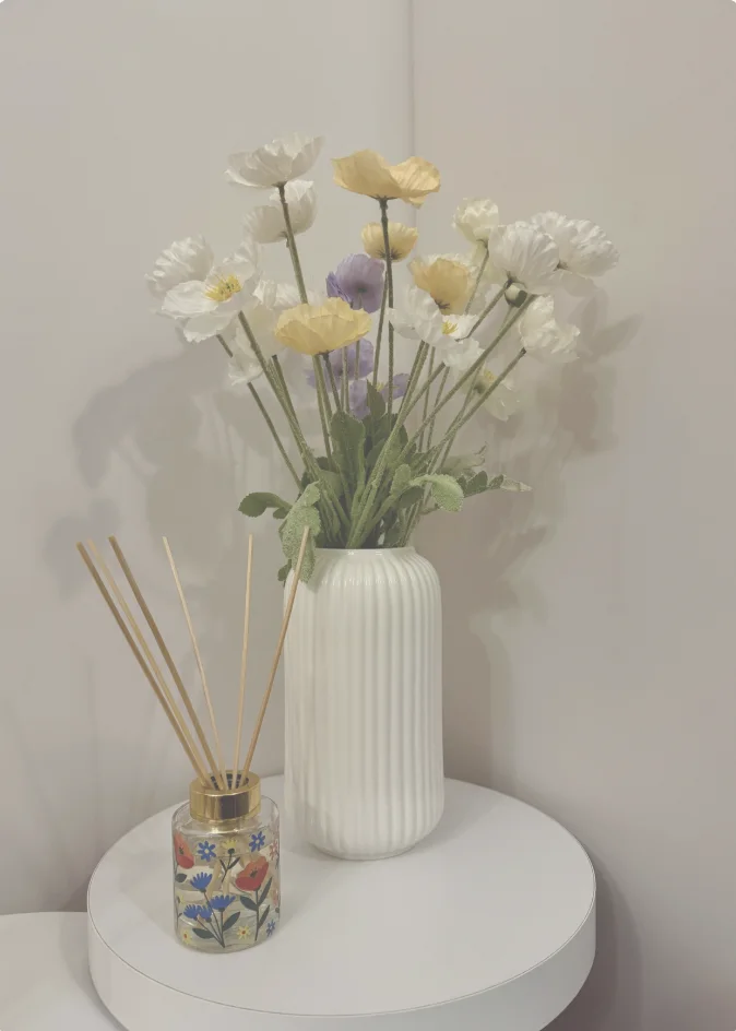 Fresh florals arranged in a white vase for arriving guests