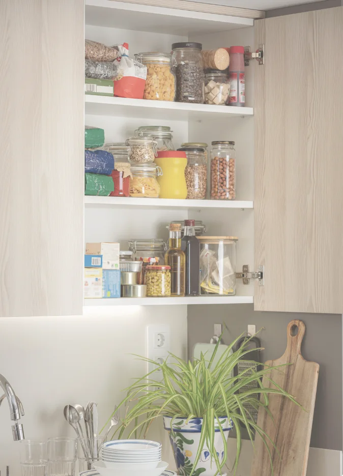 An organized pantry cabinet stocked for a guest stay